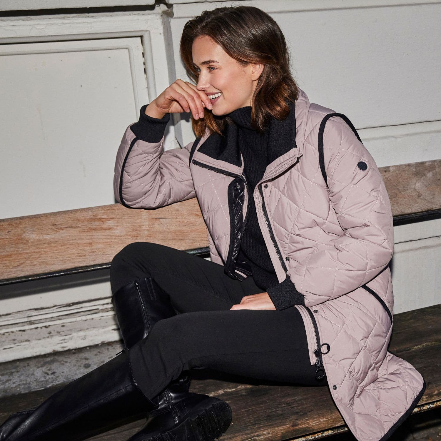 Model iført rosa quiltet overgangsjakke med sorte detaljer, stylet til efterårsmoden 2025